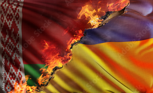 3D composite illustration depicting the national flag of the Republic of Ukraine burned by the flames of Russian and Belarusian invasions with the national flag of Belarus in background. photo