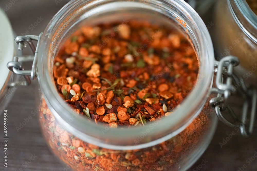 Hot spices in glass jars on a dark background Hot spices in glass jars on a dark background