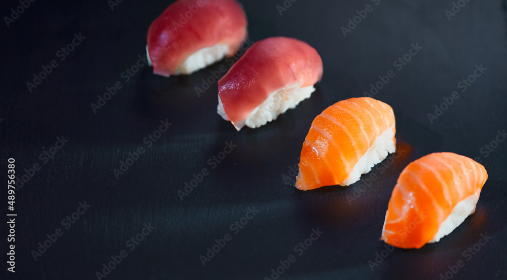 High angle view of prepared four sushi pieces against black background. High angle view of prepared four sushi pieces against black background.