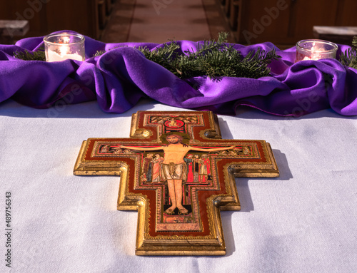 Fotografie, Tablou Vohrenbach, Germany - December 19, 2021: Christian cross with Jesus in the church in Vohrenbach and purple altar decoration in advent time