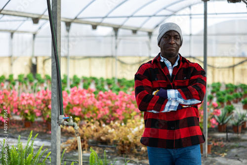 Portrait of a confident african american man farmer standing with his arms crossed in a greenhouse