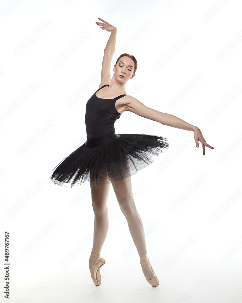 Fototapeta premium attractive ballerina stands on her fingertips. photo shoot in the studio on a white background