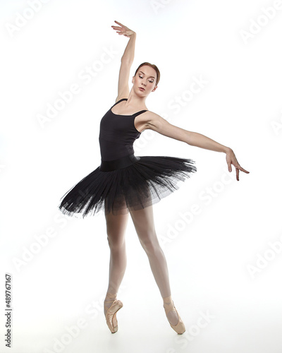 attractive ballerina stands on her fingertips. photo shoot in the studio on a white background