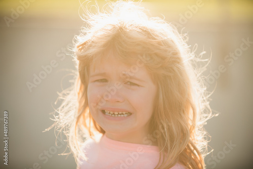 Closeup face of child boy crying outdoor. Kids cry. Unhappy sad kid face.