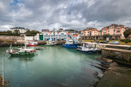 Picturesque port area of Puerto de Vega town in Asturias, Spain with beautiful blue waters and fishing boats.