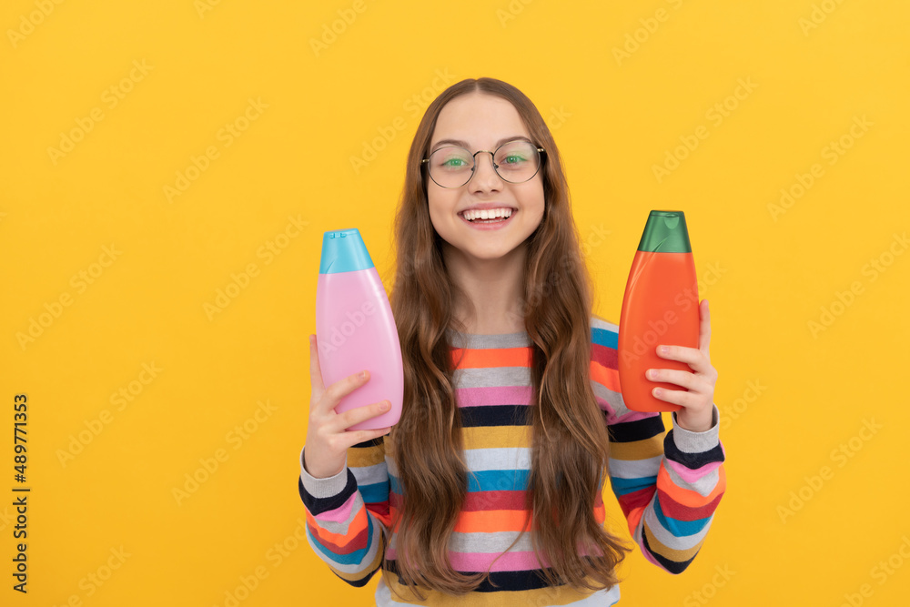 cheerful kid choosing between bottles of hair and skin care beauty cosmetics, teen health and beauty cheerful kid choosing between bottles of hair and skin care beauty cosmetics, teen health and beauty