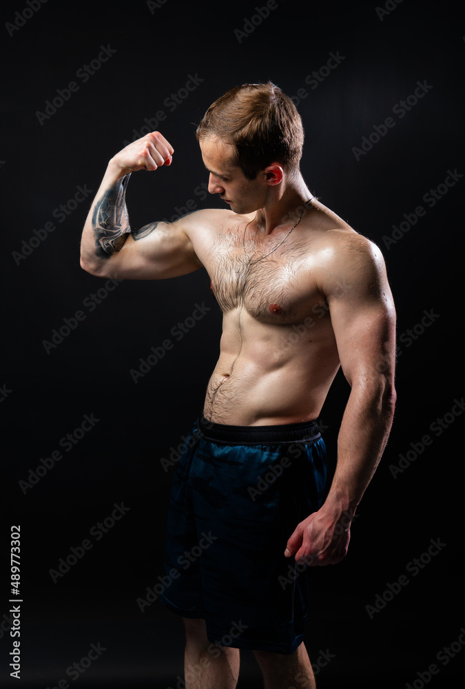 Fototapeta premium Man on black background keeps dumbbells pumped up in fitness muscle sexy torso, arm muscular man bodybuilder dumbbell, healthy lifestyle. handsome metal, guy fit