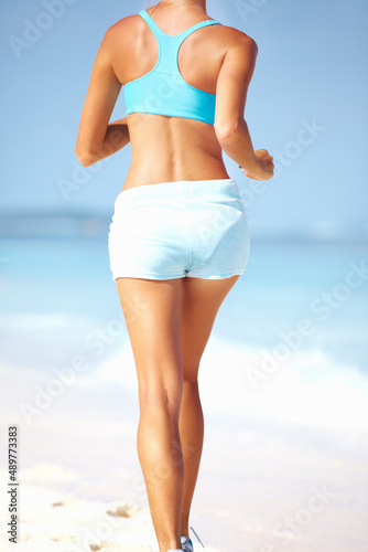 Woman jogging at beach. Cropped image of woman enjoying the jog at beach.