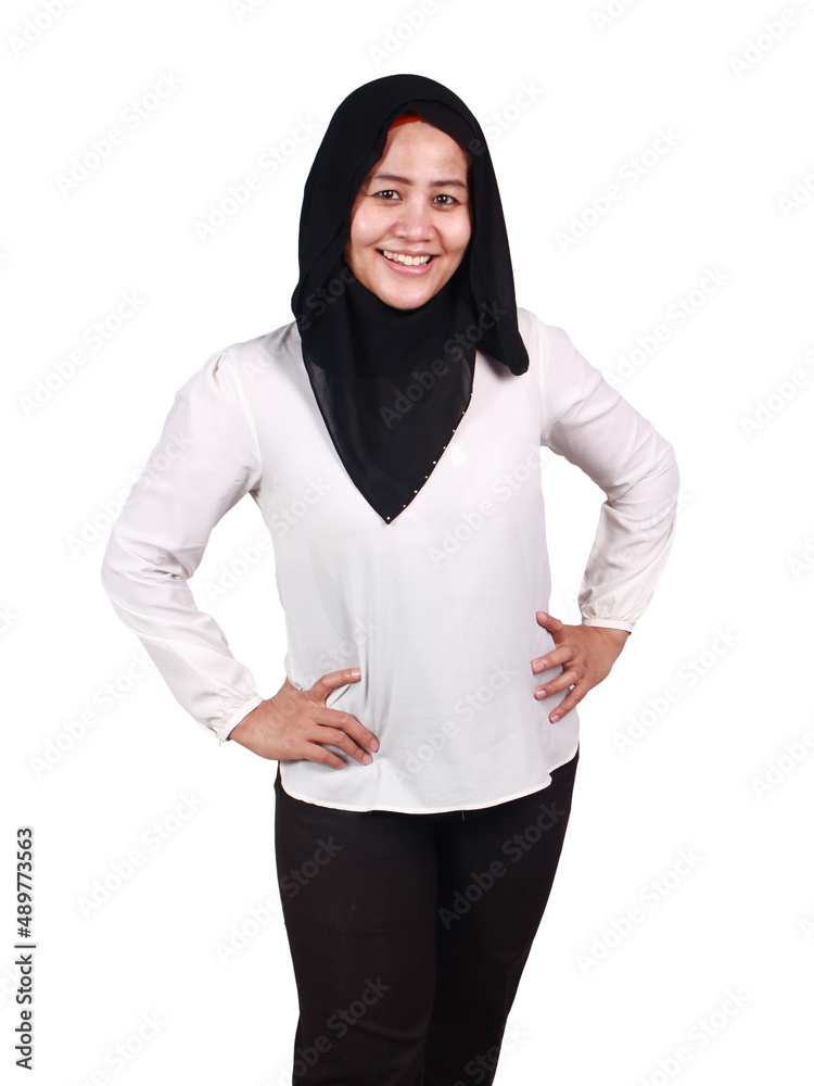 Beautiful happy successful Asian muslim lady looking at camera and smiling, hands on hips Beautiful happy successful Asian muslim lady looking at camera and smiling, hands on hips