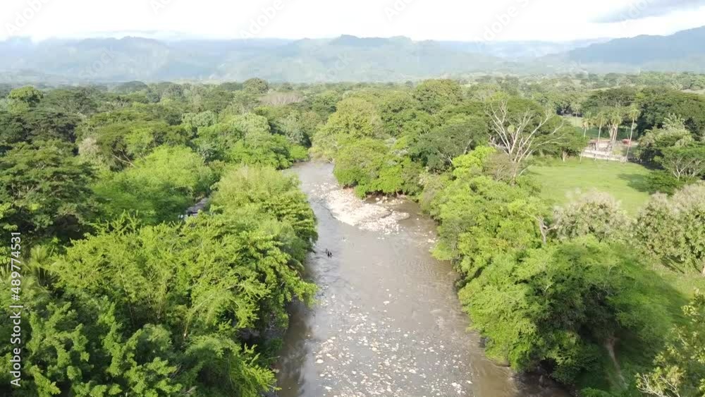 Hermoso río empedrado a lo largo del valle. Puente para cruzar