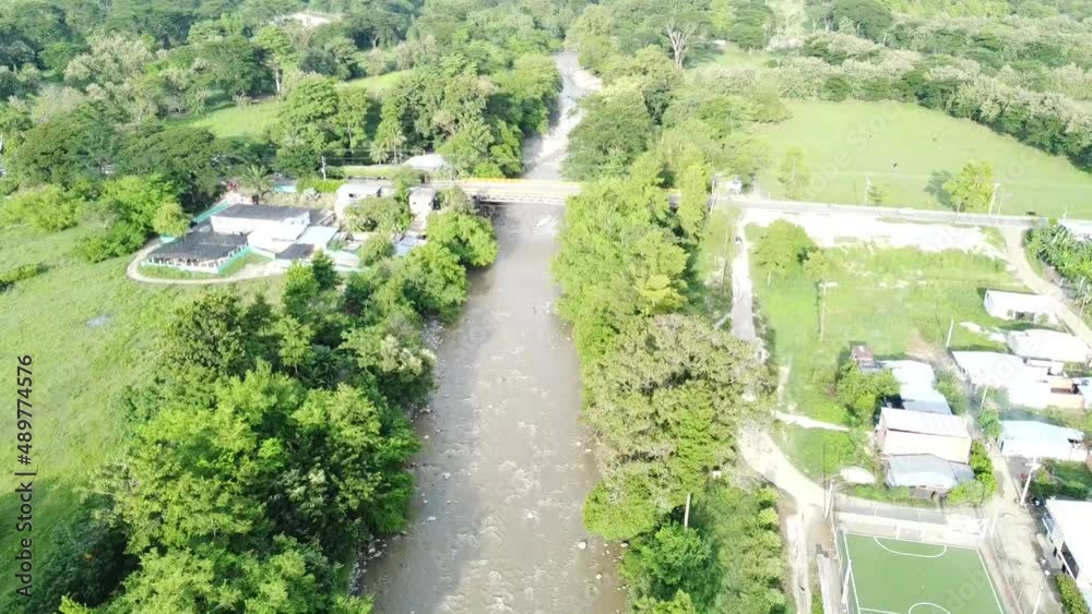 Hermoso río empedrado a lo largo del valle. Puente para cruzar