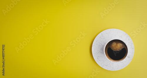 Top view of coffee in mug on yellow background with foam forming a smile. Negative space for copy. 3d rendering.