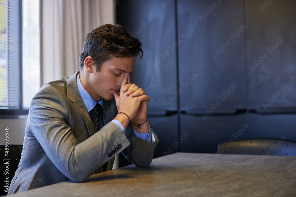 Obraz premium Its been a long day. Shot of a young businessman looking tired and stressed while sitting at his desk.