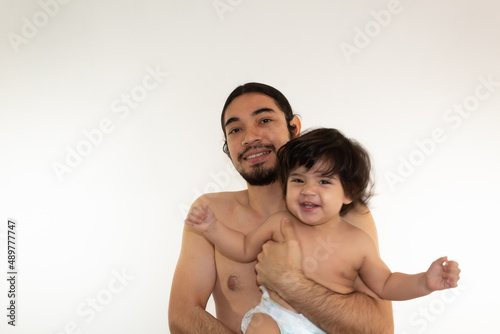 portrait of a hispanic father and son hugging on a white background