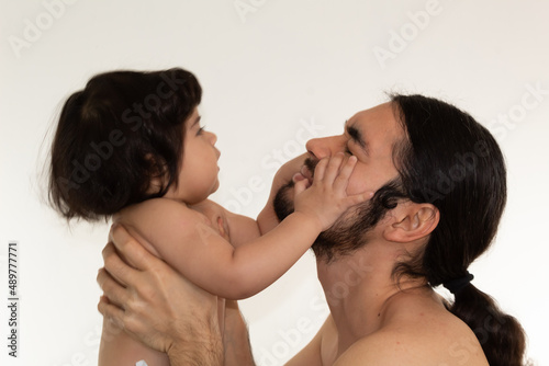 portrait of a hispanic father and son playing and smiling on a white background