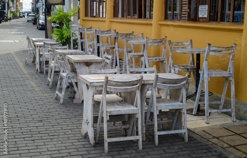 Empty wooden chairs and tables outside the restaurant in the morning  quiet and calm cobblestone Streets in Galle fort.