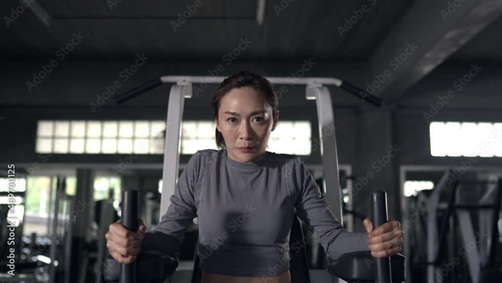 Healthy Asian athlete woman in sportswear workout exercise on weight lifting machine at fitness gym. Strong female do body building muscle weight training at sport club. Health care motivation concep Healthy Asian athlete woman in sportswear workout exercise on weight lifting machine at fitness gym. Strong female do body building muscle weight training at sport club. Health care motivation concep