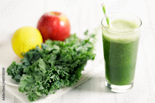 Green smoothies of kale, apple and lemon in a glass.