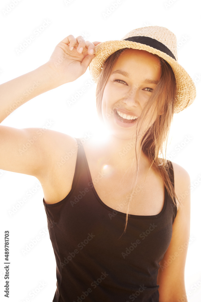 Remember your sunscreen. A playful young woman holding her hat in bright sunlight. Remember your sunscreen. A playful young woman holding her hat in bright sunlight.