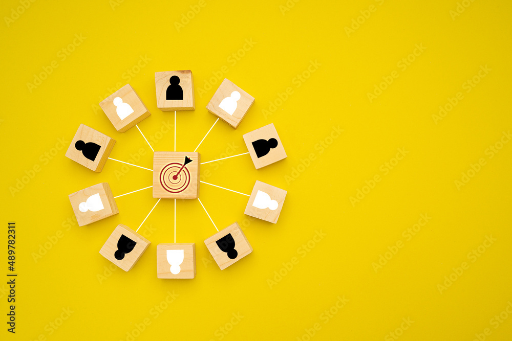 Wooden cubes with people icons focus on the goal over a yellow background - obrazy, fototapety, plakaty 