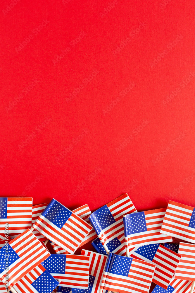 Obraz premium American flags flat lay on the red background with copy space. Happy Independence day USA.
