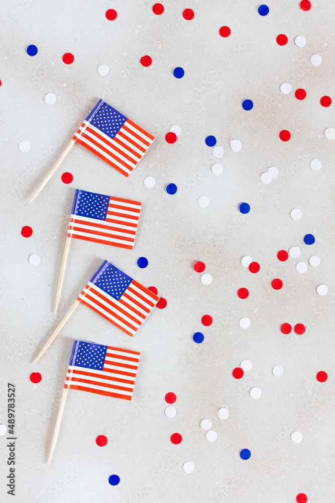 Obraz premium American flags flat lay on the white background with confetti. Happy Independence day USA.