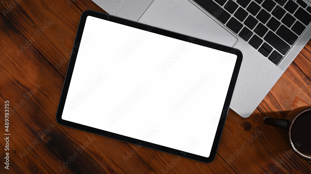 Mockup digital tablet, laptop computer and coffee cup on wooden table. Top view. Mockup digital tablet, laptop computer and coffee cup on wooden table. Top view.