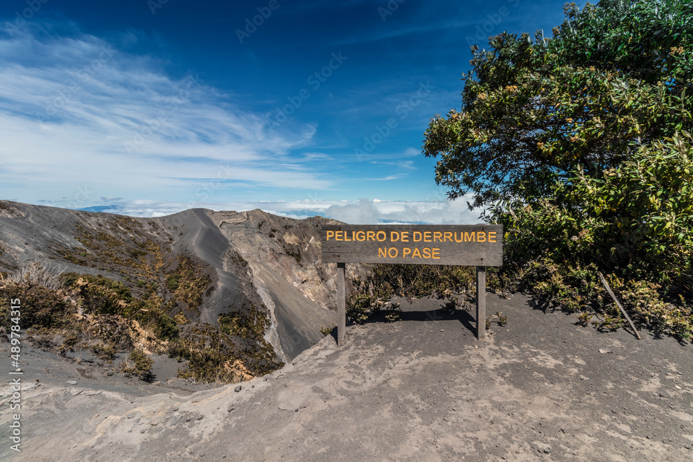 Wooden sign indicating danger of collapse and do not pass on the edge of a volcanic crater