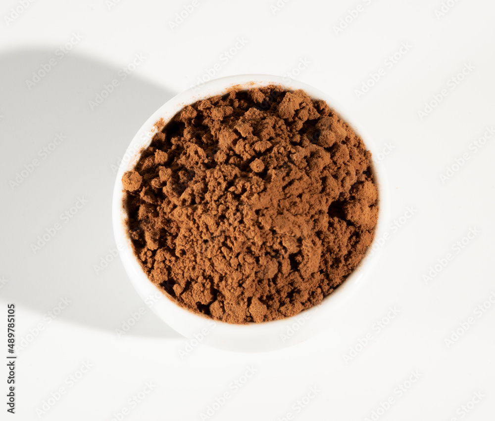 Cocoa powder in white bowl оn white background. Cocoa powder in white bowl оn white background.