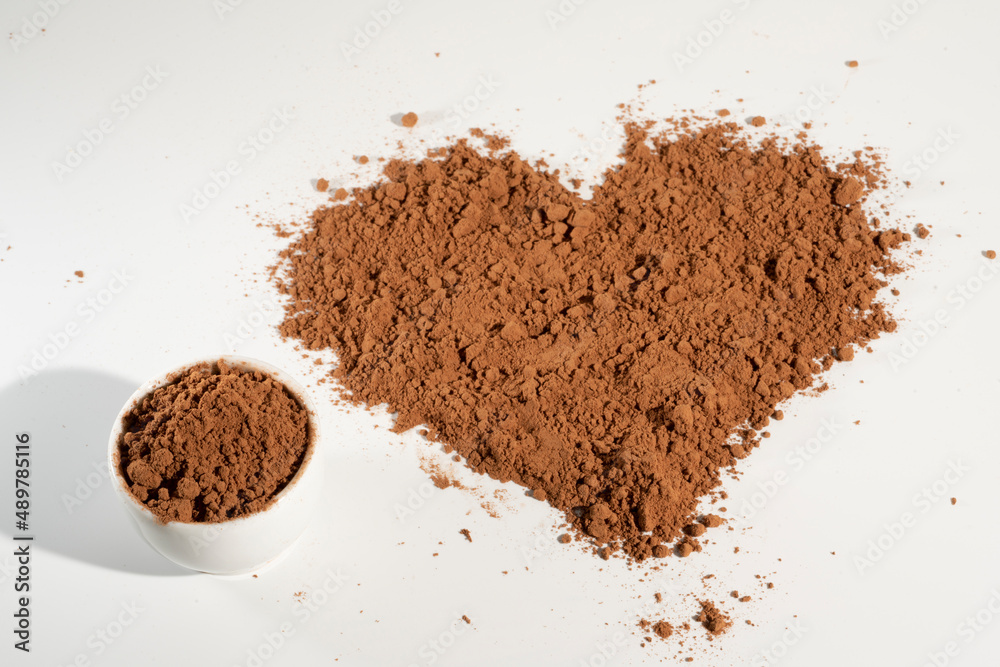 Poured heart-shaped cocoa powder, isolated on white background. Poured heart-shaped cocoa powder, isolated on white background.