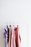 Capsule feminine cloth of pastel color don a rail.