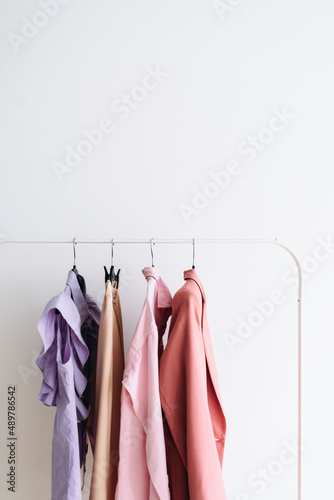 Capsule feminine cloth of pastel color don a rail.