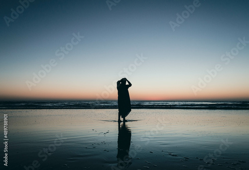 silhouette of person with umbrella on the beach