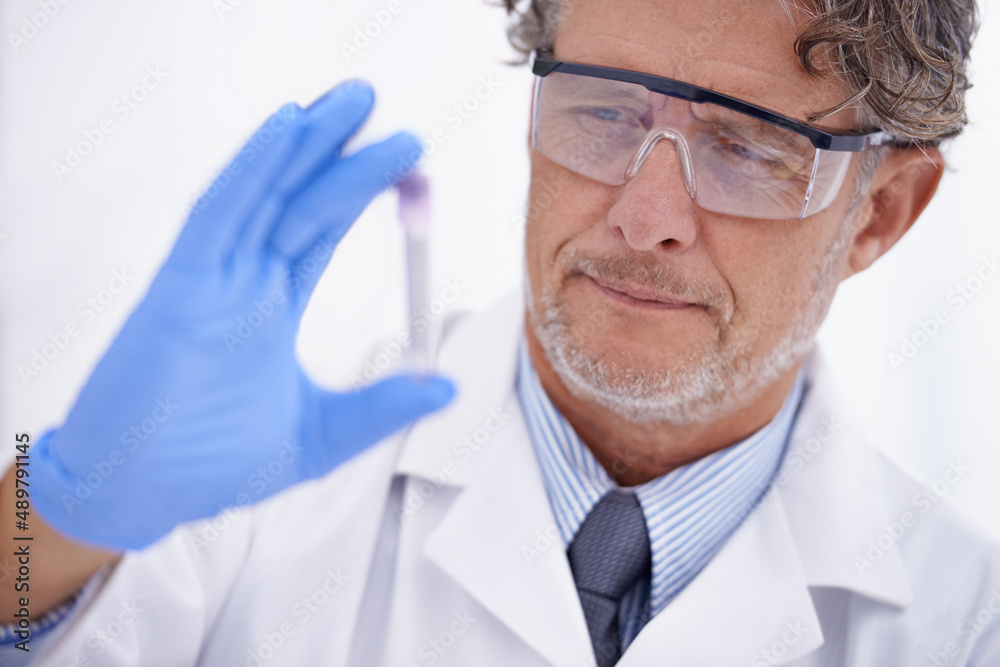 Educated observation. A cropped shot of a mature scientist looking at a test tube in his lab. Educated observation. A cropped shot of a mature scientist looking at a test tube in his lab.