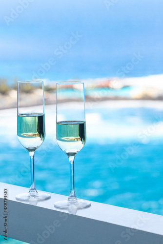 Two champagne glass on hotel room with beautiful azure ocean view in tropical country.