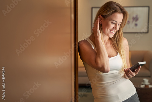 Female in hotel adjusting hair while looking at bookreader photo