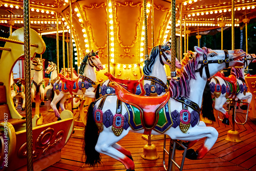 Carousel with colorful horses at amusement park, Merry go round with horse, Vintage ride attraction for children © Lazy_Bear