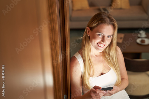 Joyful woman looking up from bookreader into camera and smiling photo
