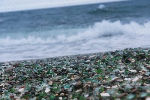 This beach in Vladivostok, Russia is covered with multi-colored glass pebbles. Cloudy day, troubled sea.