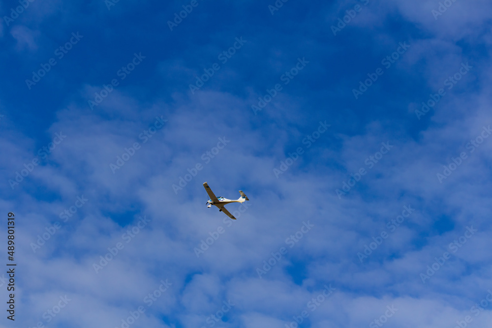 Small ultra light plane fly against blue sky with clouds. Extreme sport, travel background with copy space Small ultra light plane fly against blue sky with clouds. Extreme sport, travel background with copy space