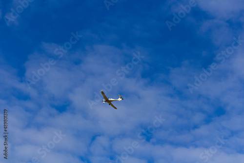 Small ultra light plane fly against blue sky with clouds. Extreme sport  travel background with copy space
