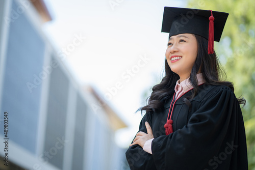 Asian woman wearing graduation gown
