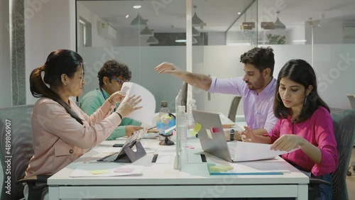 Young Indian team business people working in office with new normal lifestyle concept. Asian Diverse Team of Business Managers and Specialists Work on Desktop laptop with Rows of Tables.