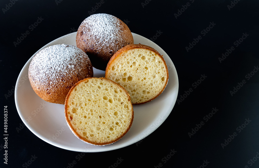 Lithuanian donuts on a plate on a black background Lithuanian donuts on a plate on a black background
