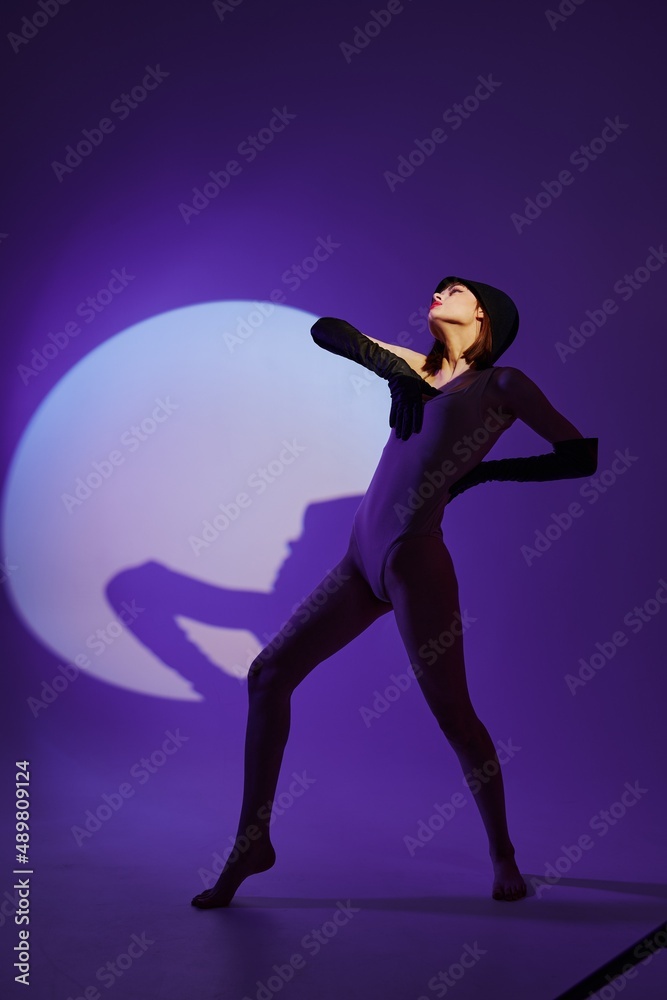 Beautiful fashionable girl posing on stage spotlight silhouette disco color background unaltered