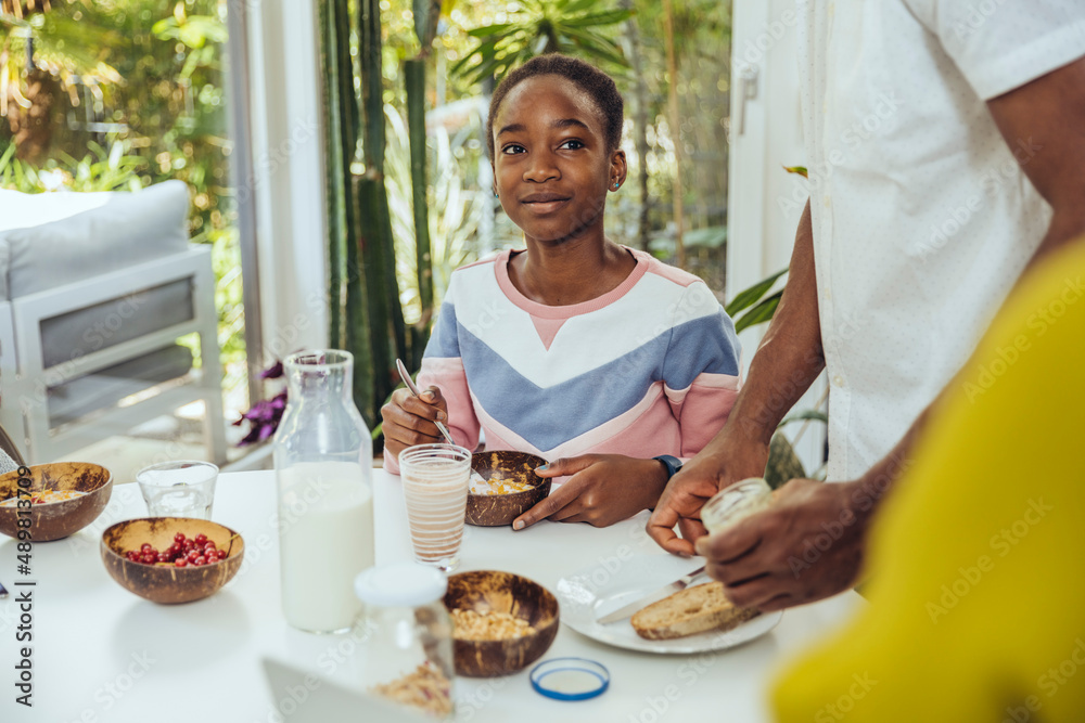 Girl having cereal at breakfast in dining room