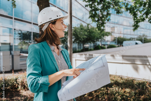 Architect wearing smart casuals holding construction plan