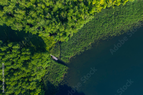Aerial view of forested shore of Grosser Linowsee lake in summer