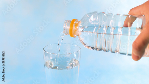 ペットボトルの水をグラスに注ぐ