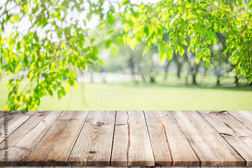 Empty wooden table with garden bokeh for a catering or food background with a country outdoor theme,Template mock up for display of product